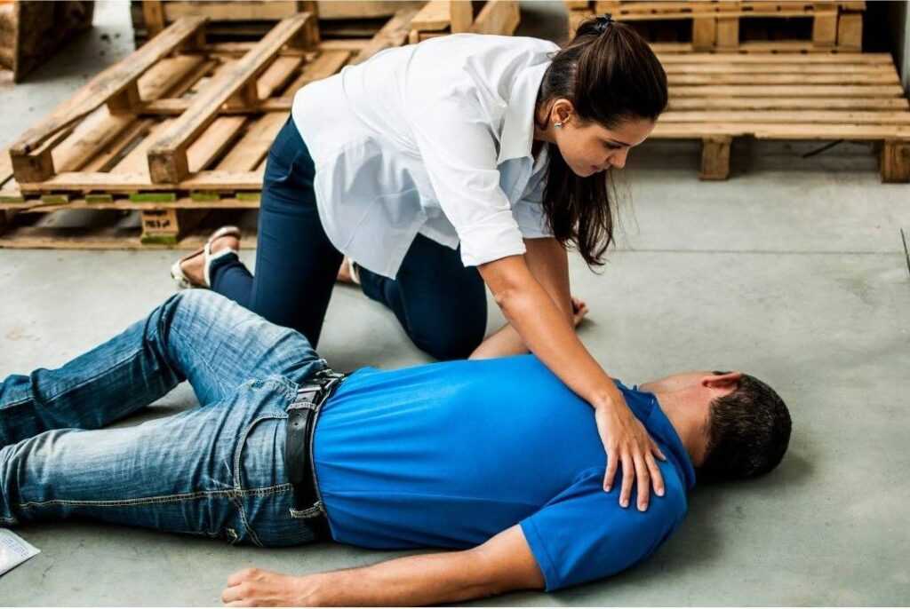 imagem de um homem em síncope (desmaio), sendo auxiliado